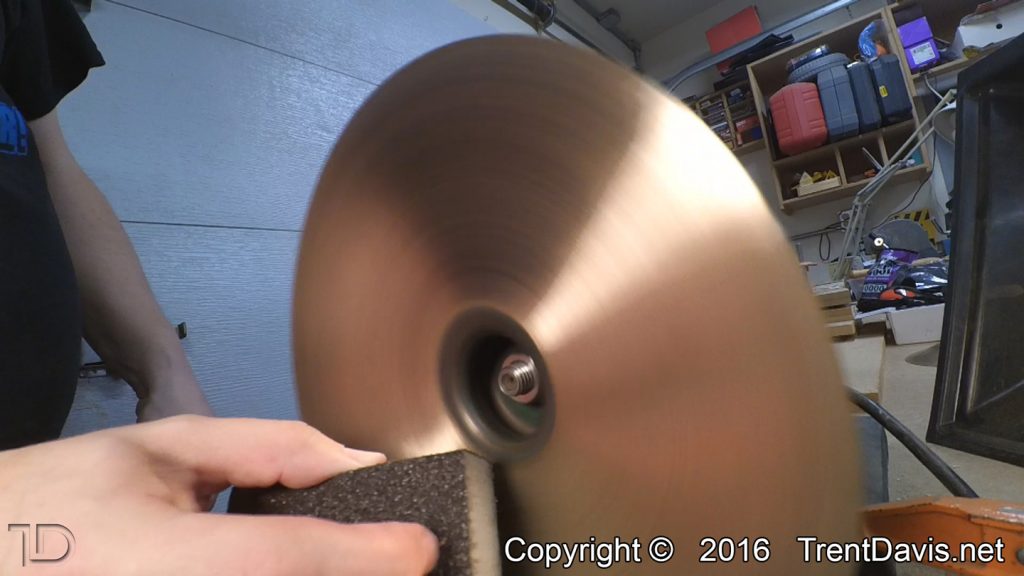 Fig. 5 - Taking the coarse sanding block to the underside of the first cymbal.