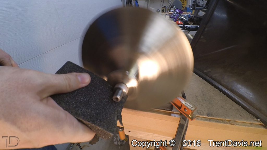 Fig. 8 - Taking a coarse sanding block to the top of the first cymbal.