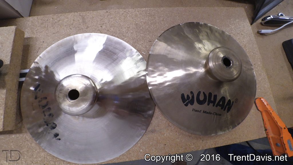 Fig. 15 - This is a shot of both cymbals. The one on the left is halfway through cleaning up the top. This was problematic due to the imbalance in that cymbal which is caused by the mounting hole being so far off-center.