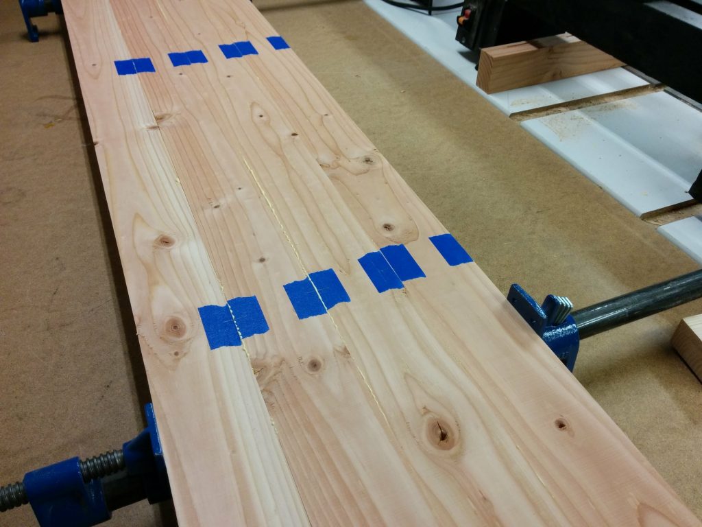 The glued up pieces being aligned to the marks on the tape.