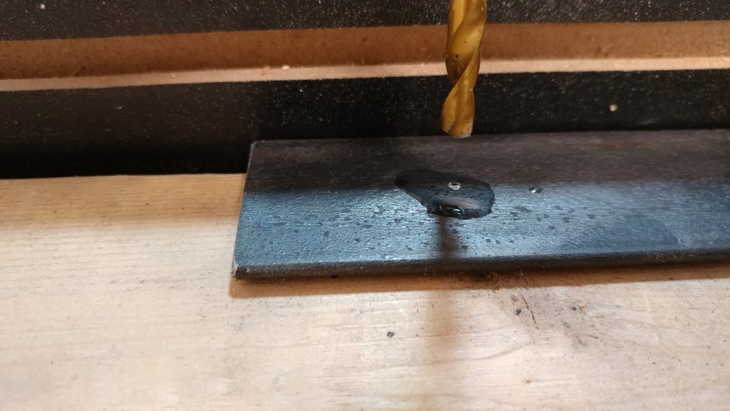 I applied a few drops of 3-in-1 oil to the steel before drilling.