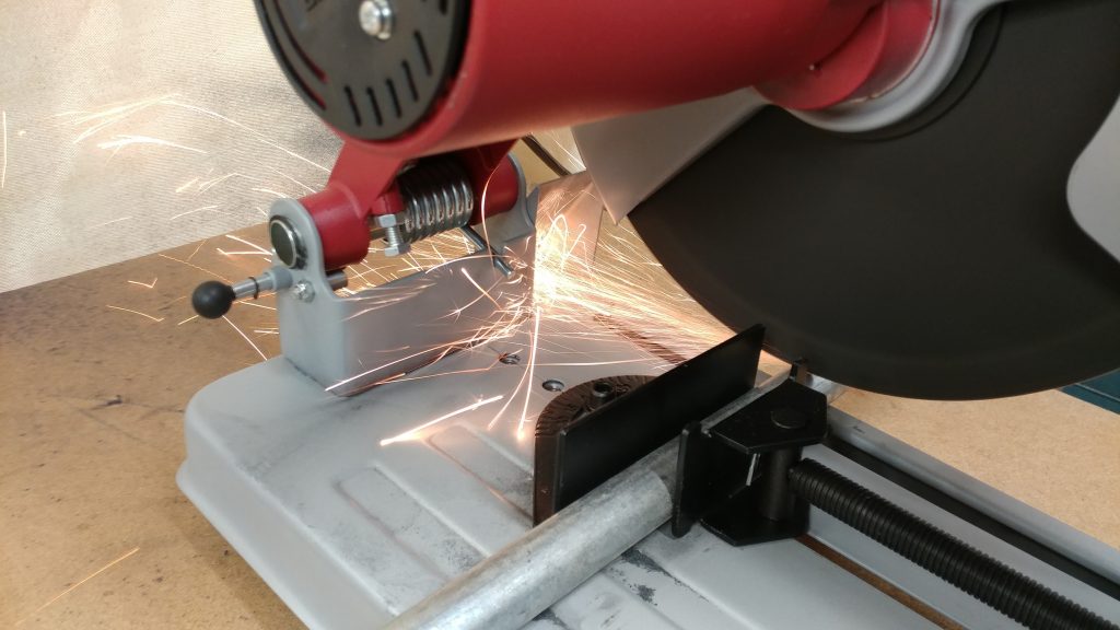 Cutting the steel tubing to size with a metal chop saw.