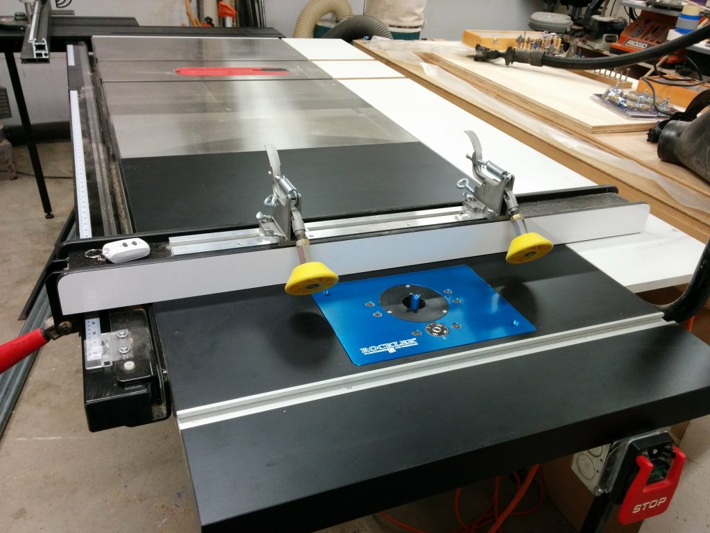 SawStop industrial cabinet saw with sliding crosscut table, extra wing, and router table.
